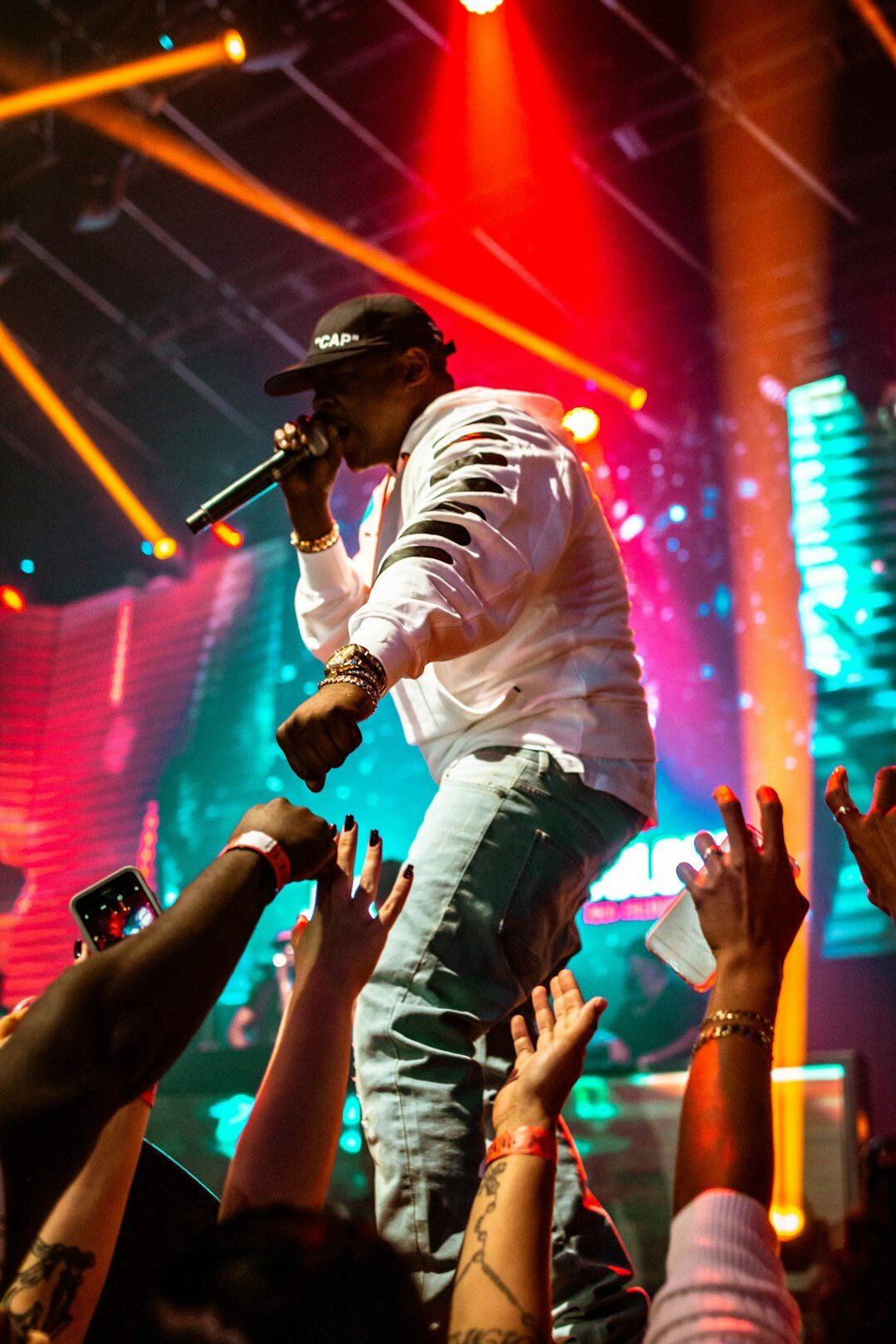 Singer performing on stage with colorful concert lighting